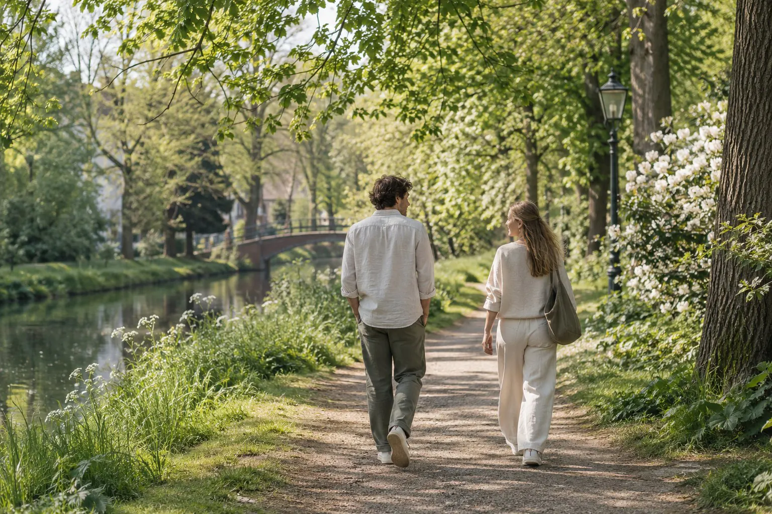 Twee jonge volwassenen wandelen samen over een groen parkpad